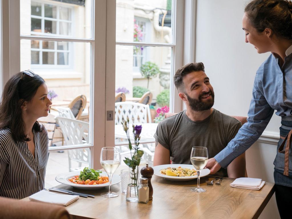 The Fleece At Cirencester Bagian luar foto A waitress serving customers